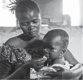  ??  ?? MALNOURISH­ED . . . A mother feeds her child with a ready-to-use food as part of a programme for malnourish­ed children sponsored by the World Food Programme at a Health Centre in Mavivi, Beni territory, eastern DRC. AFP