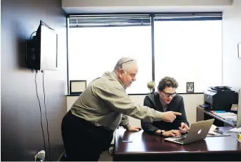  ??  ?? Jacob Melin, right, helps investment client Jim Baker last month at Crypto Consulting Group in Louisville.