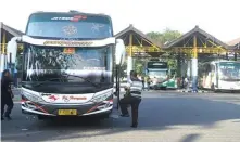  ?? UMAR WIRAHADI/JAWA POS ?? LAYANI PEMUDIK: Bus antarkota menurunkan dan menaikkan penumpang di Terminal Bunder. Arus mudik telah mencapai puncaknya kemarin.