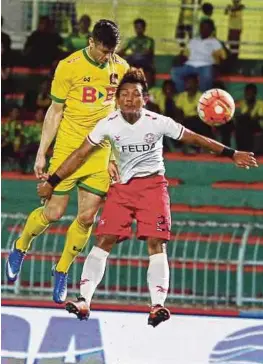  ?? [FOTO AMRAN HAMID/BH] ?? Pemain Kedah, Thiago Agusto (kiri) berebut bola dengan pemain FELDA United, Hasnizaidi Jamian pada perlawanan Liga Super di Stadium Darul Aman, malam tadi.