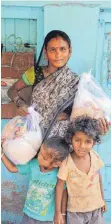  ??  ?? Eine Frau mit Kindern in einem Slum in Mumbai mit „Ccara-Covid-Packs.