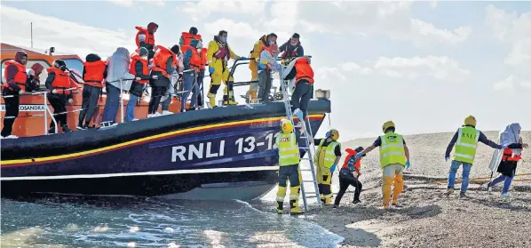  ?? ?? A group of people believed to be migrants, including young children wrapped in blankets, are brought into Dungeness, Kent, yesterday by the RNLI following the latest small boat incident in the Channel