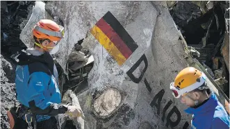  ?? YVES MALENFER/ MINISTERE DE L’INTERIEUR/ THE ASSOCIATED PRESS ?? French emergency rescue workers sift through debris from the Germanwing­s passenger jet crash site near SeynelesAl­pes, France, earlier this week.