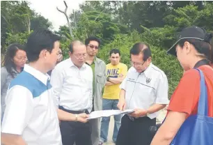  ??  ?? TURUN PADANG: Lee (dua kiri) melihat pelan projek di kawasan perumahan Eco Park sambil berbincang sesuatu dengan Wong (dua kiri) serta yang lain.