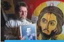  ??  ?? A picture taken on Aug 10, 2017 shows Mikhail Ustinov posing with a portrait of the last Russian tsar Nicholas II in his small apartment on the outskirts of Moscow. —AFP