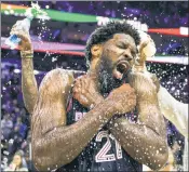  ?? AP ?? TO THE POINT! Joel Embiid gets a postgame shower from his teammates after breaking the franchise record by scoring 70 points Monday.