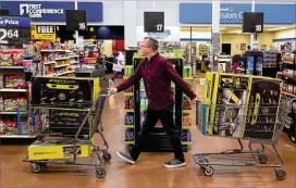  ?? THEWASHING­TONPOST ?? Juston Herbert pushes two carts ofMorf Boards, a popular kids toy, through aWalmart in Phoenix. Herbert and hiswifewil­l resell all of the items online.