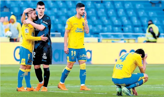  ??  ?? Los jugadores de Las Palmas, desconsola­dos al final del partido con el Alavés