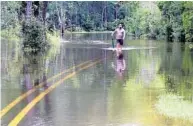  ?? AP FILE ?? A man tries to get to his car in Biloxi, Miss., last month after the area was pounded by Tropical Storm Cindy.