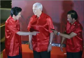  ?? AARON FAVILA — THE ASSOCIATED PRESS ?? U.S. Vice President Mike Pence, center, watches Japanese Prime Minister Shinzo Abe, left, and Brunei Sultan Hassanal Bolkiah gesture before the start of the gala dinner family photo at the APEC summit in Port Moresby, Papua New Guinea, Saturday.