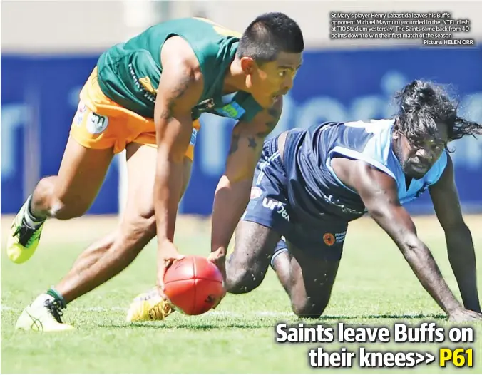  ?? Picture: HELEN ORR ?? St Mary’s player Henry Labastida leaves his Buffs’ opponent Michael Maymuru grounded in the NTFL clash at TIO Stadium yesterday. The Saints came back from 40 points down to win their first match of the season