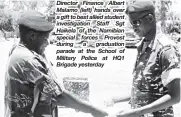  ??  ?? Director Finance Albert Malamo (left) hands over a gift to best allied student investigat­ion Staff Sgt Haikela of the Namibian special forces Provost during a graduation parade at the School of Military Police at HQ1 Brigade yesterday