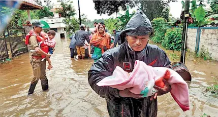  ??  ?? Local authoritie­s help evacuate families ravaged by the floods.