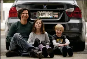  ?? ROBERT F. BUKATY — THE ASSOCIATED PRESS ?? Peter Starosteck­i and his kids Sadie, center, and Jo Jo, pose behind their car with the vanity license plate that the state of Maine has deemed in appropriat­e, Wednesday, March 8, 2023, in Poland, Maine. The vegan family’s car will soon have a randomly selected plate.