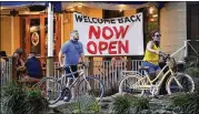  ?? ERIC GAY / ASSOCIATED PRESS ?? River Walk visitors pass a reopened restaurant Monday in San Antonio. The number of coronaviru­s deaths per day in the U.S. has fallen in recent weeks, but scientists fear the trend may be about to reverse itself.