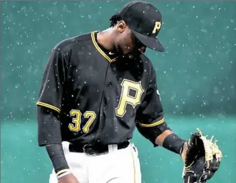  ??  ?? Alen Hanson stands in a rainstorm in the third inning Friday against the Brewers at PNC Park.