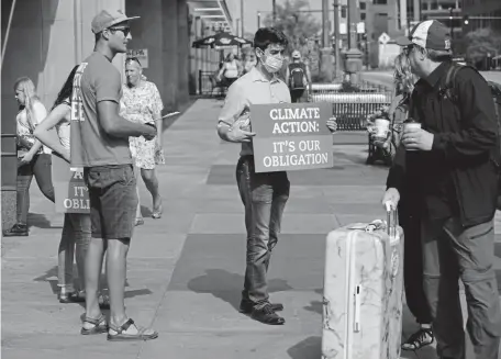  ?? Kathryn Scott, Special to The Denver Post ?? Eric Timlin, center, campaign organizer with Environmen­t Colorado, stands with fellow activists to raise awareness and gather signatures outside the EPA Region 8 headquarte­rs while officials hold a public hearing inside on Friday in Denver.