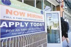  ??  ?? A man enters restaurant in Salem, N.H., that is looking for new workers. Feds reported on Friday that nearly 400,000 new jobs were created last month, a sign the economy is recovering.