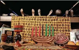  ?? AJC FILE ?? The Kwanzaa setting is placed purposely before an exhibit representi­ng slaves in the hold of a slave ship at a previous Kwanzaa ceremony at the APEX Museum.