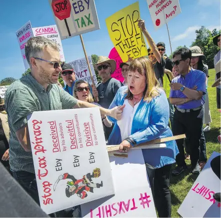  ?? ARLEN REDEKOP/PNG ?? Protesters rally against a school tax on homes valued over $3 million outside Jericho Pool & Gym. While recent polls had indicated support for the hike, the town hall told a different story.