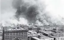  ??  ?? The Greenwood neighborho­od is burned down during the 1921 race riot that killed 300 people. Tulsa Historical Society & Museum