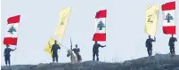  ?? (Aziz Taher/Reuters) ?? GUNMEN HOLD Hezbollah and Lebanese flags at a rally near Marjayoun, southern Lebanon, in 2015.