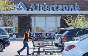  ?? JOEL ANGEL JUAREZ/THE REPUBLIC ?? Albertsons employee Shelly Elmquist gathers shopping carts at the Albertsons parking lot of a Phoenix location.