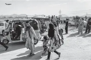  ?? Photos by Jim Huylebroek / New York Times ?? People gather near the airport in Kabul, Afghanista­n. Despite a security warning from the U.S. Embassy, crowds of people wanting to leave the country remain outside the airport.