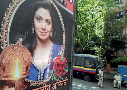  ?? PHOTO: AP ?? Policemen stand guard outside Indian actress Sridevi Kapoor’s residence in Mumbai, near tributes left by fans.