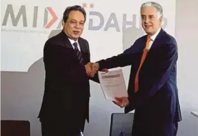  ??  ?? Malaysian Investment Developmen­t Authority (Mida) chief executive officer (CEO) Datuk Azman Mahmud (left) exchanging documents with Daher CEO Didier Kayat after the signing of a memorandum of understand­ing in Paris last Friday.