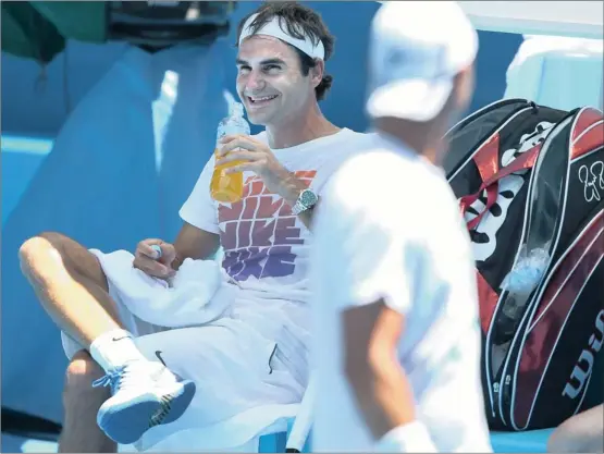  ?? Picture: MICHAEL DODGE, GALLO IMAGES ?? COOL GUY: Despite high temperatur­es and concern over the heat at next week’s Australian Open, Roger Federer was in relaxed mood as he greeted Australia’s Lleyton Hewitt during a practice session at Melbourne Park yesterday.