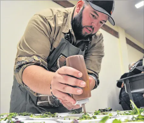  ?? SARA ERICSSON ?? Mike Schroeder puts a finishing touch on hors d’oeuvres he prepped for Devour! The Food Film Fest’s Sip and Savour event held Oct. 23 in Kentville.