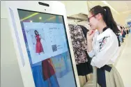  ?? PROVIDED TO CHINA DAILY ?? A female customer tries a “magic mirror” system at a Tmall popup store in Shanghai.