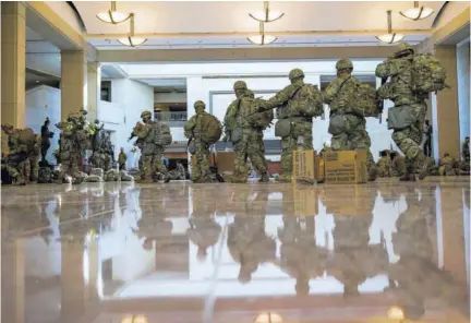  ?? (Photo: AP) ?? Troops move inside the Capitol Visitor’s Center to reinforce security yesterday at the Capitol in Washington while the House of Representa­tives was pursuing an article of impeachmen­t against President Donald Trump for his role in inciting an angry mob to storm the Capitol last week.