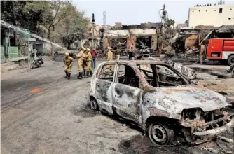  ?? AP PHOTO/MANISH SWARUP ?? Fire fighters douse a fire at a tire market in New Delhi, India, on Wednesday. At least 24 people were killed in three days of clashes in New Delhi.