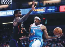  ?? (Reuters) ?? SACRAMENTO KINGS guard De’Aaron Fox (5) drives past Phoenix Suns center Deandre Ayton during the Kings’ 117-104 home victory over the Suns on Sunday night.