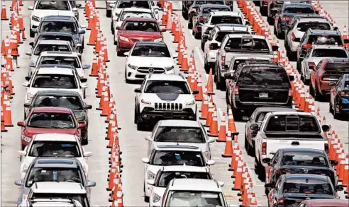  ?? WILFREDO LEE/AP ?? Lines of cars wait Friday at a coronaviru­s testing site outside of Hard Rock Stadium in Miami Gardens, Florida.