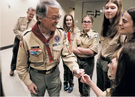  ?? Carlos Avila Gonzalez / The Chronicle ?? Scouting official Bill Lew fist-bumps Ashlyn Weber before a Scouts BSA ceremony welcoming girls as new members.