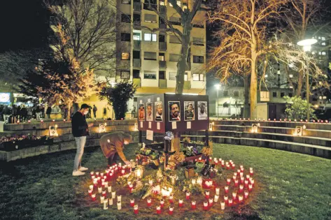  ??  ?? People light candles in front of a kiosk where several people were killed in a racist attack one year ago in Hanau, Germany, Feb. 19, 2021.