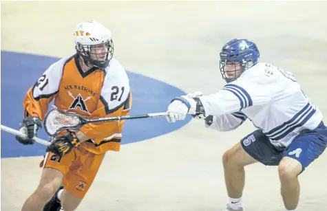  ?? BOB TYMCZYSZYN/STANDARD STAFF ?? The St. Catharines Athletics hosted Six Nations Arrows in the final home game of the regular season for the A's Wednesday at Jack Gatecliff Arena in St. Catharines. Here Alex Pace (5) stick checks Cody Ward (21) .