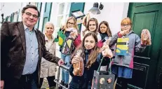  ?? RP-FOTO: ANNE ORTHEN ?? Die Grundschül­er und Schulleite­rin Ursula Brümmer übergeben ihre Laternen an Bezirksbür­germeister Karsten Kunert.