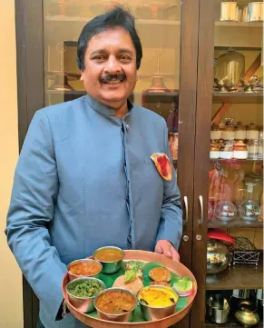 ??  ?? From left: Maharaja Pushpraj Singh of Rewa holds up a Bagheli thali; a plate of Indrahar without the gravy. Opposite: Spicy chicken biryani in a bowl.