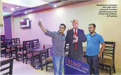  ??  ?? Bangladesh­i customers take selfie with a cutout US President Donald Trump at the Trump Cafe in Dhaka. — AFP photos