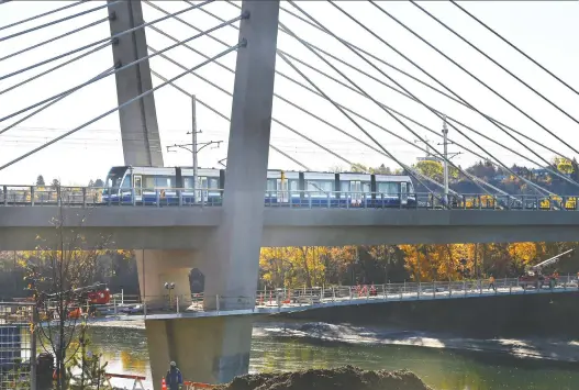  ?? ED KAISER ?? A train crosses the Tawatinâ Bridge Tuesday as part of testing for the new Valley Line Southeast LRT line. The contractor for the project announced a further delay Tuesday.