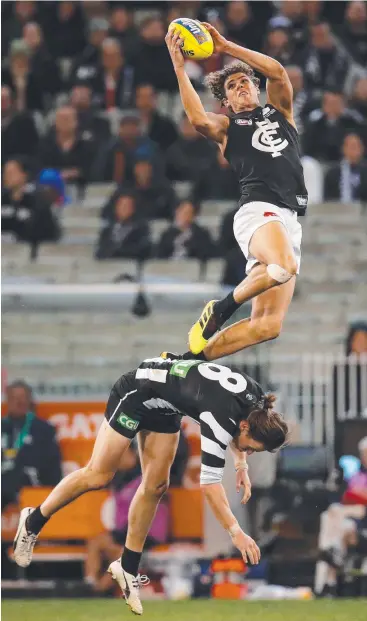  ?? Picture: AFL MEDIA ?? GREEN SHOOT: Charlie Curnow of the Blues takes a spectacula­r mark over Tom Langdon of the Magpies during Saturday’s match at the MCG.