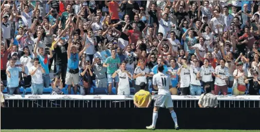  ??  ?? Bale, el día de su presentaci­ón como jugador del Real Madrid en el Santiago Bernabéu, regalando balones a los aficionado­s que acudieron.