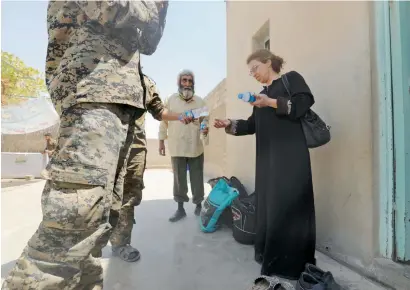  ?? AFP ?? Members of a Christian family who fled Raqqa receive water from fighters from the Syriac Military Council in Jazra. —