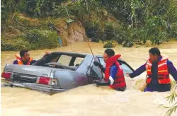 ?? BBXPIX ?? Search and rescue personnel inspecting the victims' car submerged in floodwater­s in Kampung Baru Sungai Kob, Kulim, Kedah yesterday.