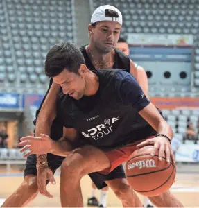  ?? ZVONKO KUCELIN/AP ?? Bulgarian tennis player Grigor Dimitrov, rear, plays basketball with Serbia’s
Novak Djokovic last Thursday in Zadar, Croatia. Dimitrov has tested positive for coronaviru­s.