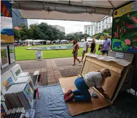  ??  ?? Minnesota painter Holly Sue Foss packages a large painting she sold during the two-day Bayou City Art Festival Downtown.